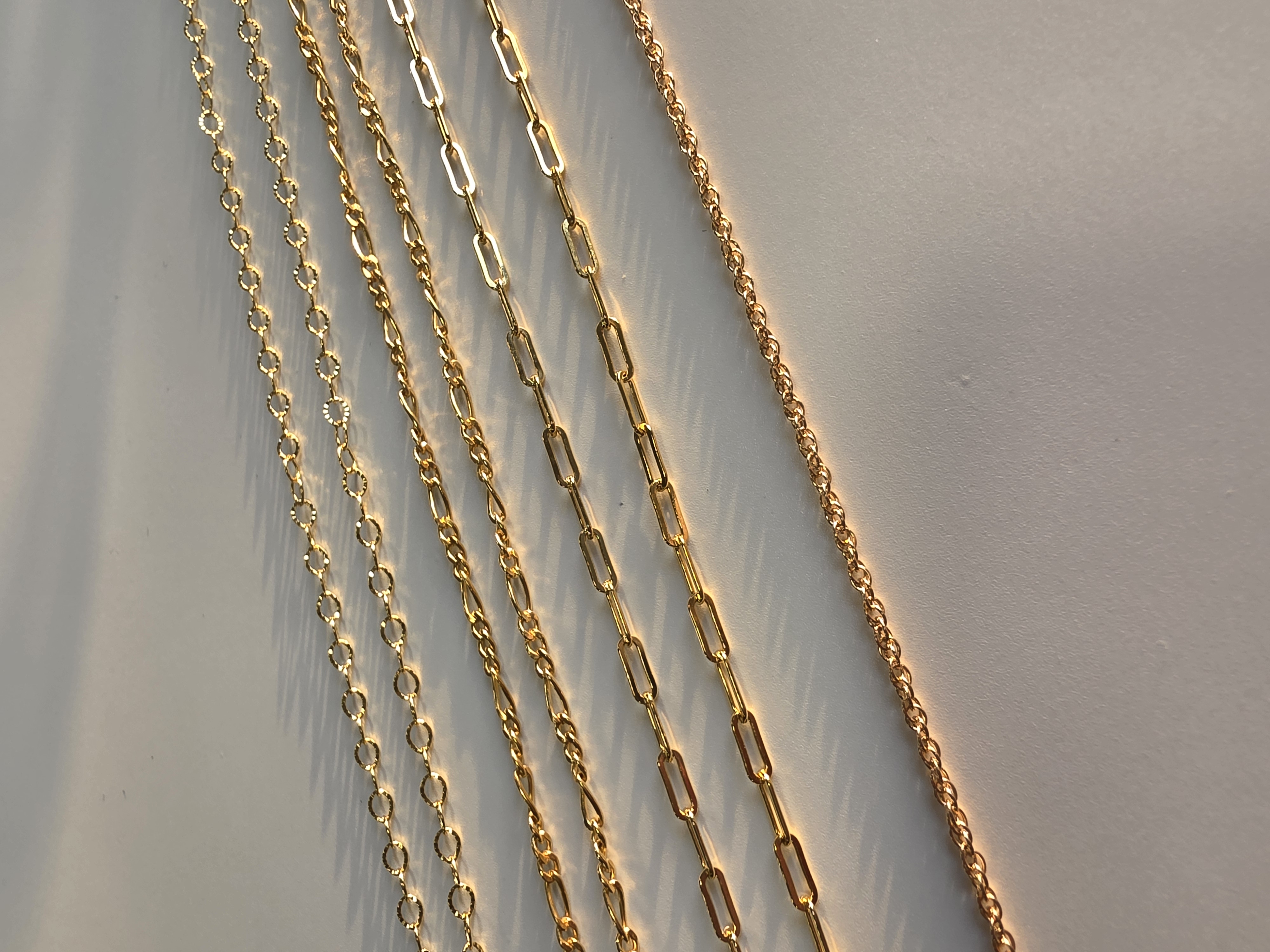 Permanent jewellery - piece, gold chains in low light