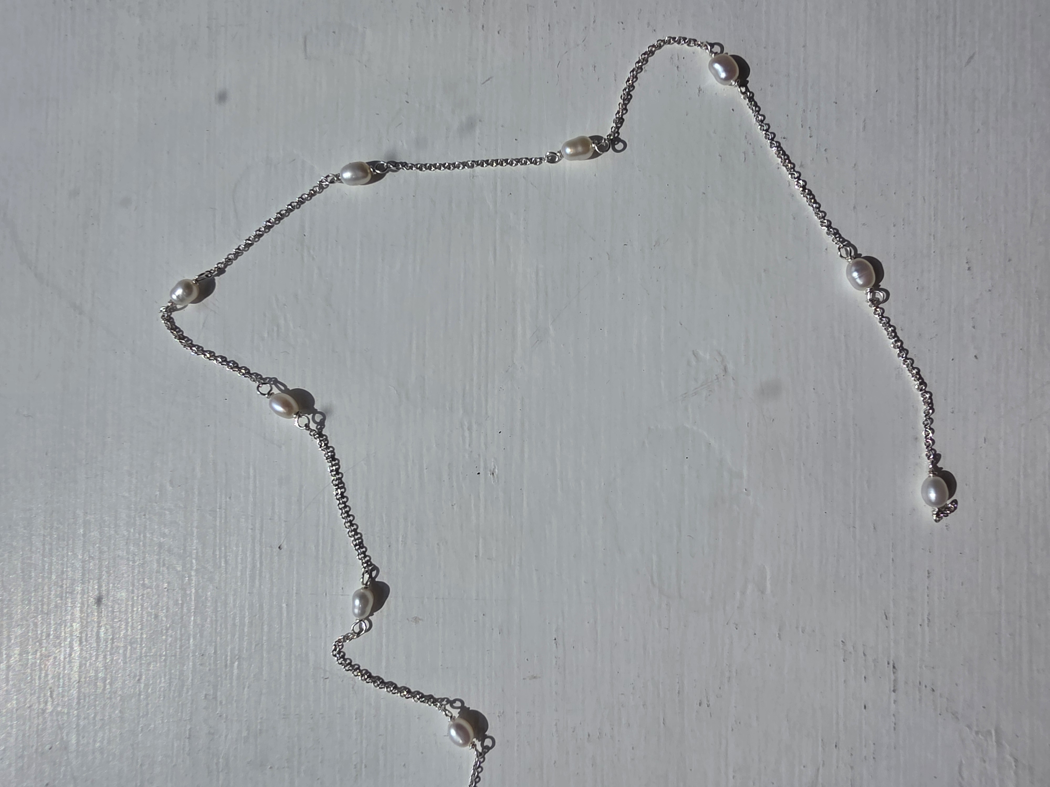 Permanent jewellery - piece, pearl chain on white background