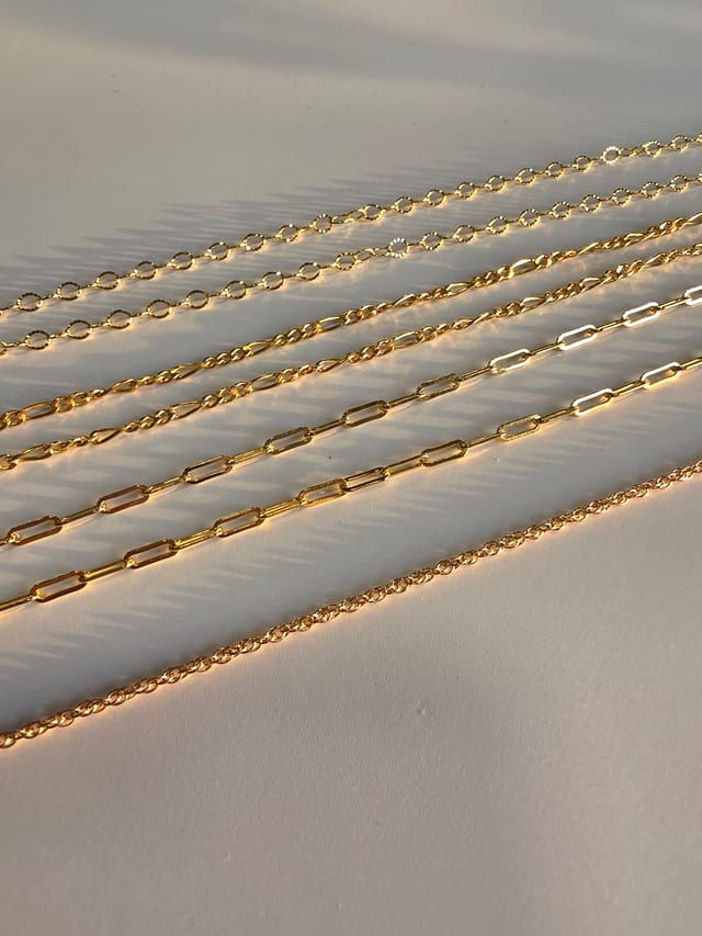 Permanent jewellery - piece, gold chains in low light