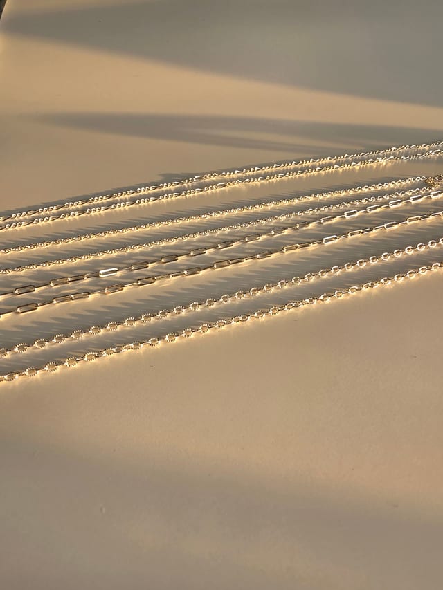 Permanent jewellery - piece, silver chains in low light